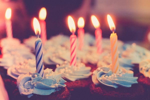 A photo of cupcakes with lit birthday candles