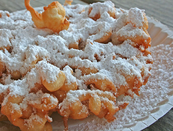 Photo of a funnel cake with powdered sugar on top